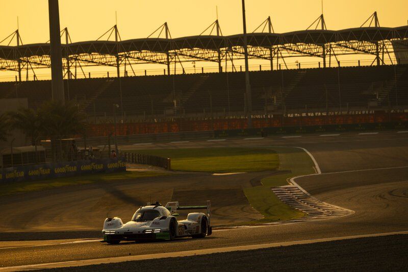 Auto de competición en plena curva bajo la luz dorada